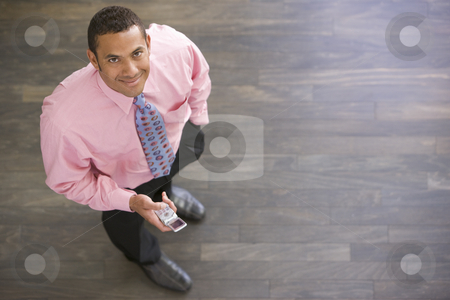 To use this stock image in your creative project, please select the size you need over to the right and click the "Add to Cart" button.
Your downloaded image will come with the Cutcaster watermark removed so don’t worry about the watermark you see on this page. Businessman standing indoors with cellular phone smiling stock photo, by Monkey Business Images