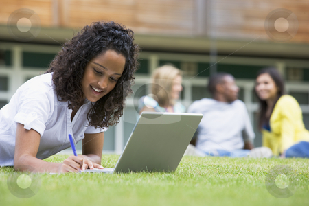 To use this stock image in your creative project, please select the size you need over to the right and click the "Add to Cart" button.
Your downloaded image will come with the Cutcaster watermark removed so don’t worry about the watermark you see on this page. Young woman using laptop on campus lawn, with other students rel stock photo, by Monkey Business Images