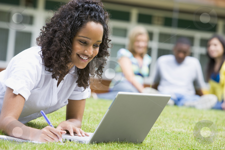 To use this stock image in your creative project, please select the size you need over to the right and click the "Add to Cart" button.
Your downloaded image will come with the Cutcaster watermark removed so don’t worry about the watermark you see on this page. Young woman using laptop on campus lawn, with other students rel stock photo, by Monkey Business Images