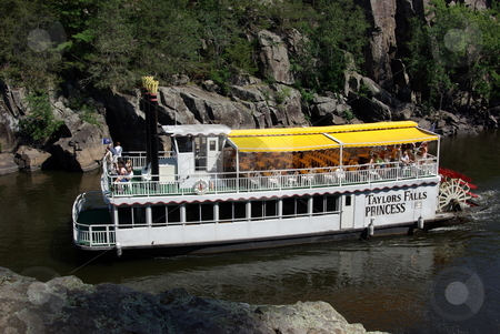 To use this stock image in your creative project, please select the size you need over to the right and click the "Add to Cart" button.
Your downloaded image will come with the Cutcaster watermark removed so don’t worry about the watermark you see on this page. St. Croix River paddleboat stock photo, A favorite summer daytrip travel destination for people living in the Minneapolis - St. Paul metropolitan area is the town of Taylor Falls on the Minnesota border with Wisconsin. Travelers enjoy a paddleboat aboard the Taylor Falls Princess viewing the rocky cliffs of the St. Croix River as well as rock climbing and hiking in Taylor Falls State Park. by Dennis Thomsen