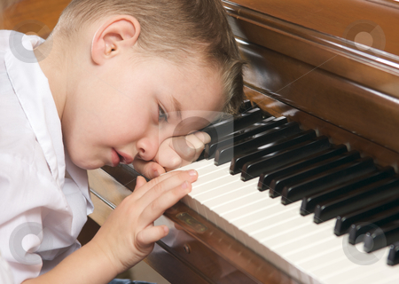 To use this stock image in your creative project, please select the size you need over to the right and click the "Add to Cart" button.
Your downloaded image will come with the Cutcaster watermark removed so don’t worry about the watermark you see on this page. Young Boy Playing the Piano stock photo, Young Boy with Head on Hand Playing the Piano by Andy Dean