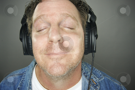 To use this stock image in your creative project, please select the size you need over to the right and click the "Add to Cart" button.
Your downloaded image will come with the Cutcaster watermark removed so don’t worry about the watermark you see on this page. Man Wearing Headphones stock photo, Man with Eyes Shut Wearing Headphones Enjoying His Music on a Grey Background. by Andy Dean
