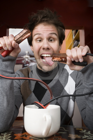 To use this stock image in your creative project, please select the size you need over to the right and click the "Add to Cart" button.
Your downloaded image will come with the Cutcaster watermark removed so don’t worry about the watermark you see on this page. Coffee Jolt stock photo, Young man holding jumper cables coming out of coffee mug by Scott Griessel