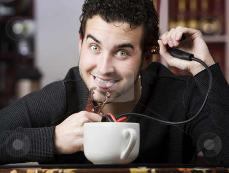 To use this stock image in your creative project, please select the size you need over to the right and click the "Add to Cart" button.
Your downloaded image will come with the Cutcaster watermark removed so don’t worry about the watermark you see on this page. Coffee Jolt stock photo, Young man holding jumper cables coming out of coffee mug by Scott Griessel
