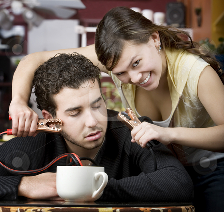 To use this stock image in your creative project, please select the size you need over to the right and click the "Add to Cart" button.
Your downloaded image will come with the Cutcaster watermark removed so don’t worry about the watermark you see on this page. Coffee Jolt stock photo, Young woman holding jumper cables coming out of coffee mug to man's head by Scott Griessel