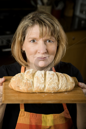 To use this stock image in your creative project, please select the size you need over to the right and click the "Add to Cart" button.
Your downloaded image will come with the Cutcaster watermark removed so don’t worry about the watermark you see on this page. Woman in Kitchen with Bread stock photo, Woman in a residential kitchen with bread by Scott Griessel