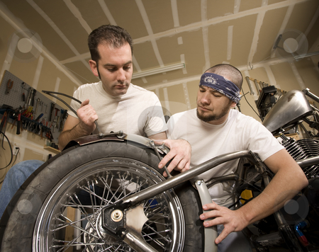 To use this stock image in your creative project, please select the size you need over to the right and click the "Add to Cart" button.
Your downloaded image will come with the Cutcaster watermark removed so don’t worry about the watermark you see on this page. Two Motorcycle Mechanics Placing a Fender stock photo, Two men working on a chopper-style motorcycle by Scott Griessel