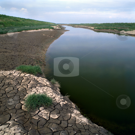 To use this stock image in your creative project, please select the size you need over to the right and click the "Add to Cart" button.
Your downloaded image will come with the Cutcaster watermark removed so don’t worry about the watermark you see on this page. Dry river stock photo, An almost dry river bed with ctacked earth by the sides by Paul Phillips