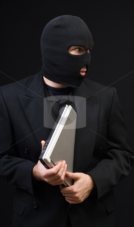 To use this stock image in your creative project, please select the size you need over to the right and click the "Add to Cart" button.
Your downloaded image will come with the Cutcaster watermark removed so don’t worry about the watermark you see on this page. Stealing Office Equipment stock photo, A business thief wearing a black balaclava is stealing a laptop computer by Richard Nelson