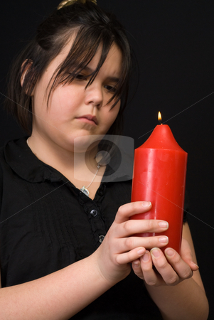 To use this stock image in your creative project, please select the size you need over to the right and click the "Add to Cart" button.
Your downloaded image will come with the Cutcaster watermark removed so don’t worry about the watermark you see on this page. Worried Child stock photo, A young girl looks worried as she is holding a large red candle, shot against a dark background by Richard Nelson