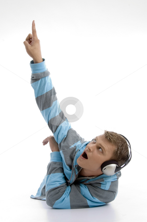 To use this stock image in your creative project, please select the size you need over to the right and click the "Add to Cart" button.
Your downloaded image will come with the Cutcaster watermark removed so don’t worry about the watermark you see on this page. Laying young man with headphone indicating upward stock photo, Laying young man with headphone indicating upward with white background by Imagery Majestic