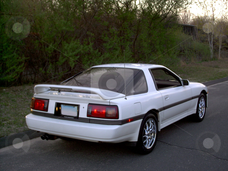 To use this stock image in your creative project, please select the size you need over to the right and click the "Add to Cart" button.
Your downloaded image will come with the Cutcaster watermark removed so don’t worry about the watermark you see on this page. White Sports Car stock photo, A white sports car parked on the side of the road. by Todd Arena