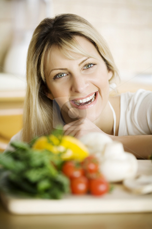 To use this stock image in your creative project, please select the size you need over to the right and click the "Add to Cart" button.
Your downloaded image will come with the Cutcaster watermark removed so don’t worry about the watermark you see on this page. Healhty cooking stock photo, Young woman in her kitchen, behind fresh ingredients by Liv Friis-Larsen