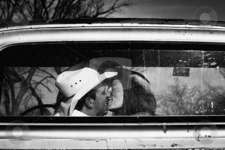 To use this stock image in your creative project, please select the size you need over to the right and click the "Add to Cart" button.
Your downloaded image will come with the Cutcaster watermark removed so don’t worry about the watermark you see on this page. Cowboy Kiss stock photo, Cowboy and girlfriend kissing in through the back window of a pickup truck by Scott Griessel