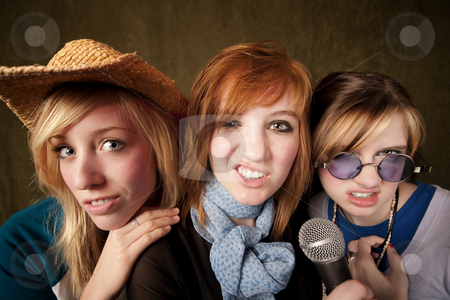To use this stock image in your creative project, please select the size you need over to the right and click the "Add to Cart" button.
Your downloaded image will come with the Cutcaster watermark removed so don’t worry about the watermark you see on this page. Three Young Girls with Microphone Making Faces stock photo, Portrait of three pretty young girls with a microphone making faces on green background by Scott Griessel