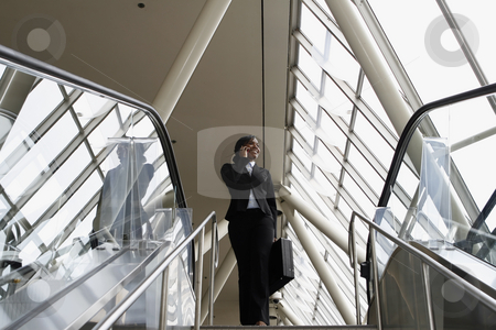To use this stock image in your creative project, please select the size you need over to the right and click the "Add to Cart" button.
Your downloaded image will come with the Cutcaster watermark removed so don’t worry about the watermark you see on this page. Businesswoman on Stairs - Horizontal stock photo, Attractive businesswoman smiling and talking on her phone as she stands at the top of the stairs by Orange Line Media