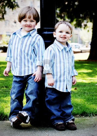 To use this stock image in your creative project, please select the size you need over to the right and click the "Add to Cart" button.
Your downloaded image will come with the Cutcaster watermark removed so don’t worry about the watermark you see on this page. Brothers in the Park - Vertical stock photo, Two brothers dressed identically in a striped shirt and blue jeans standing shoulder to shoulder in a park. High-key style, vertically-framed shot. by Orange Line Media