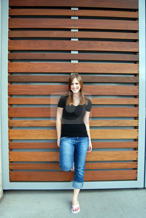 To use this stock image in your creative project, please select the size you need over to the right and click the "Add to Cart" button.
Your downloaded image will come with the Cutcaster watermark removed so don’t worry about the watermark you see on this page. Teen Leaning Against Teak Paneling - Vertical, Smiling stock photo, Vertically framed outdoor shot of a smiling teenage girl leaning against a Teak paneled wall. by Orange Line Media