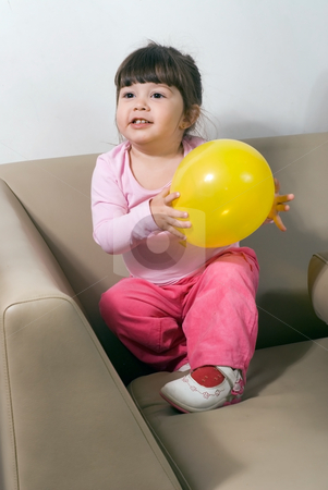 To use this stock image in your creative project, please select the size you need over to the right and click the "Add to Cart" button.
Your downloaded image will come with the Cutcaster watermark removed so don’t worry about the watermark you see on this page. Girl with Yellow Balloon stock photo, Cute young girl playing with a bright yellow balloon on a couch in her living room by Orange Line Media