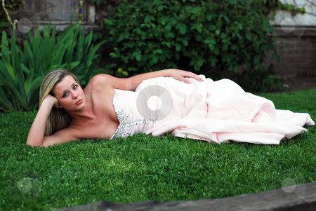 To use this stock image in your creative project, please select the size you need over to the right and click the "Add to Cart" button.
Your downloaded image will come with the Cutcaster watermark removed so don’t worry about the watermark you see on this page. Cute Blond Woman - Horizontal stock photo, Attractive blond woman in a bridesmaid's dress lying on a lush green lawn propping her head up on her hand. Horizontally framed shot. by Orange Line Media