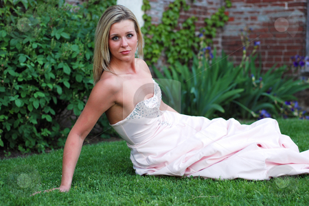 To use this stock image in your creative project, please select the size you need over to the right and click the "Add to Cart" button.
Your downloaded image will come with the Cutcaster watermark removed so don’t worry about the watermark you see on this page. Cute Blond Woman - Horizontal stock photo, Attractive blond woman in a bridesmaid's dress sitting on a lush green lawn propping herself up with her arm. by Orange Line Media