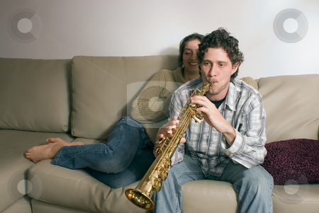 To use this stock image in your creative project, please select the size you need over to the right and click the "Add to Cart" button.
Your downloaded image will come with the Cutcaster watermark removed so don’t worry about the watermark you see on this page. Musical Couple at Home stock photo, Young couple relaxing on their couch together. He is serenading her with his saxophone by Orange Line Media