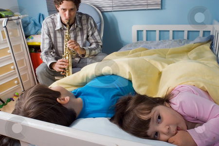 To use this stock image in your creative project, please select the size you need over to the right and click the "Add to Cart" button.
Your downloaded image will come with the Cutcaster watermark removed so don’t worry about the watermark you see on this page. Father and Children stock photo, Young father putting his kids to bed with his music. (In a good way) by Orange Line Media