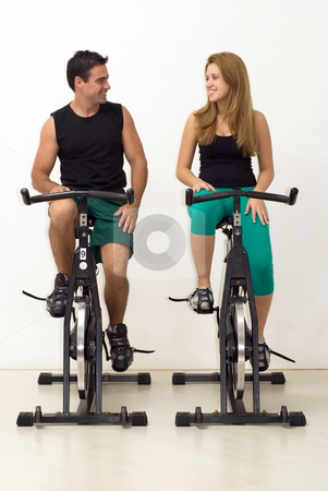 To use this stock image in your creative project, please select the size you need over to the right and click the "Add to Cart" button.
Your downloaded image will come with the Cutcaster watermark removed so don’t worry about the watermark you see on this page. Young Couple at the Gym stock photo, Attractive young couple looking at each other and smiling while working out on exercise bikes. Vertically framed, isolated shot. by Orange Line Media