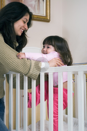 To use this stock image in your creative project, please select the size you need over to the right and click the "Add to Cart" button.
Your downloaded image will come with the Cutcaster watermark removed so don’t worry about the watermark you see on this page. Mother and Daughter stock photo, Mother lifting her daughter out of a crib. Vertically framed shot by Orange Line Media
