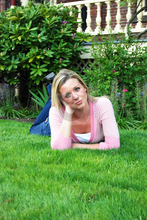 To use this stock image in your creative project, please select the size you need over to the right and click the "Add to Cart" button.
Your downloaded image will come with the Cutcaster watermark removed so don’t worry about the watermark you see on this page. Beautiful Woman in Field stock photo, Attractive young woman lying on a lush green lawn with her head on one hand. Vertically framed shot by Orange Line Media