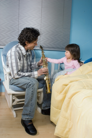 To use this stock image in your creative project, please select the size you need over to the right and click the "Add to Cart" button.
Your downloaded image will come with the Cutcaster watermark removed so don’t worry about the watermark you see on this page. Father and Daughter stock photo, Father and daughter playing the saxophone for his daughter as she gets ready for bed by Orange Line Media
