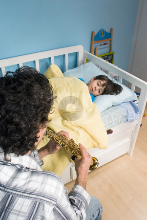 To use this stock image in your creative project, please select the size you need over to the right and click the "Add to Cart" button.
Your downloaded image will come with the Cutcaster watermark removed so don’t worry about the watermark you see on this page. Father and Son - Vertical Format stock photo, Young father playing his song a son to get him to go to sleep by Orange Line Media