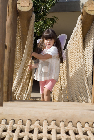 To use this stock image in your creative project, please select the size you need over to the right and click the "Add to Cart" button.
Your downloaded image will come with the Cutcaster watermark removed so don’t worry about the watermark you see on this page. Cute Girl stock photo, Adorable young girl climbing gingerly up a rope bridge. Vertically framed shot. by Orange Line Media