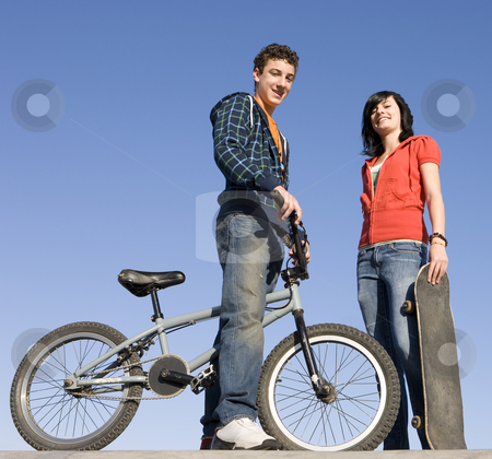 To use this stock image in your creative project, please select the size you need over to the right and click the "Add to Cart" button.
Your downloaded image will come with the Cutcaster watermark removed so don’t worry about the watermark you see on this page. Teens at skatepark stock photo, Teens with a bike and skateboard hang out at the skate park by Rick Becker-Leckrone
