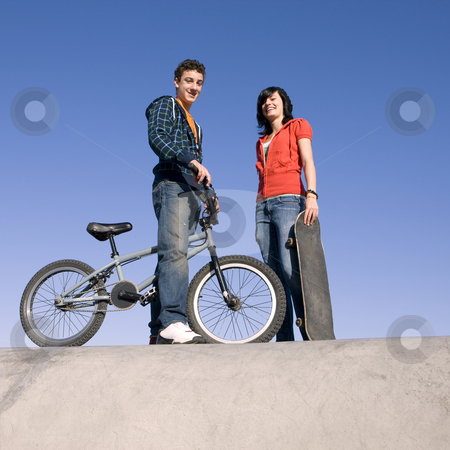To use this stock image in your creative project, please select the size you need over to the right and click the "Add to Cart" button.
Your downloaded image will come with the Cutcaster watermark removed so don’t worry about the watermark you see on this page. Teens at skatepark stock photo, Teens with a bike and skateboard hang out at the skate park by Rick Becker-Leckrone