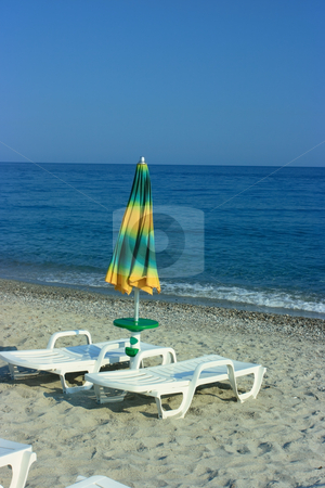 To use this stock image in your creative project, please select the size you need over to the right and click the "Add to Cart" button.
Your downloaded image will come with the Cutcaster watermark removed so don’t worry about the watermark you see on this page. Folded umbrella on a beach stock photo, One folded umbrella and two chaise-longue by Natalia Macheda