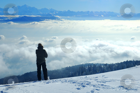 To use this stock image in your creative project, please select the size you need over to the right and click the "Add to Cart" button.
Your downloaded image will come with the Cutcaster watermark removed so don’t worry about the watermark you see on this page. Looking across the valley stock photo, A skier, high on a slope in the Swiss Jura mountains in winter, takes a break from skiing and gazes across to the French Alps. The valley below is filled with cloud, what the Swiss call the 'Mer de Brouillard' (sea of mist). by Alistair Scott