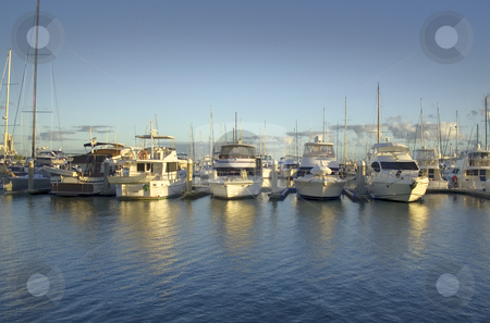 To use this stock image in your creative project, please select the size you need over to the right and click the "Add to Cart" button.
Your downloaded image will come with the Cutcaster watermark removed so don’t worry about the watermark you see on this page. Golden Marina stock photo, Golden light from sunrise breaks over the marina. by Brett Mulcahy