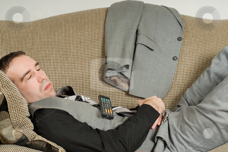 To use this stock image in your creative project, please select the size you need over to the right and click the "Add to Cart" button.
Your downloaded image will come with the Cutcaster watermark removed so don’t worry about the watermark you see on this page. Sleeping Businessman stock photo, A young businessman sleeping on the sofa with a television remote on his belly by Richard Nelson