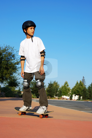 To use this stock image in your creative project, please select the size you need over to the right and click the "Add to Cart" button.
Your downloaded image will come with the Cutcaster watermark removed so don’t worry about the watermark you see on this page. Teen Boy on Skateboard stock photo, Teenage boy riding a skateboard on the sidewalk of a parking lot on a sunny day with blue sky and trees in the background. by Denis Radovanovic