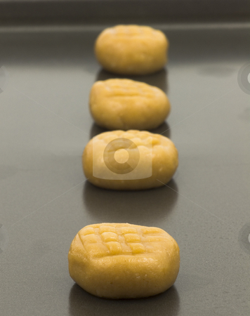 To use this stock image in your creative project, please select the size you need over to the right and click the "Add to Cart" button.
Your downloaded image will come with the Cutcaster watermark removed so don’t worry about the watermark you see on this page. Peanut butter cookie dough stock photo, Peanut butter cookie dough on baking pan close up by John Teeter