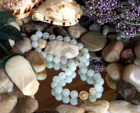 To use this stock image in your creative project, please select the size you need over to the right and click the "Add to Cart" button.
Your downloaded image will come with the Cutcaster watermark removed so don’t worry about the watermark you see on this page. Green bead necklace with gold claps and zen pebbles stock photo, Collection of green bead necklace, shells, spa items by Jill Reid