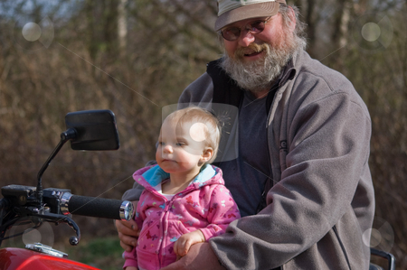 To use this stock image in your creative project, please select the size you need over to the right and click the "Add to Cart" button.
Your downloaded image will come with the Cutcaster watermark removed so don’t worry about the watermark you see on this page. Grandfather and Baby Grandchild on Motorcycle stock photo, Rough rugged grandfather is proudly smiling while showing his little grandaughter how to sit on a motorcycle. by Valerie Garner