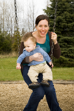 To use this stock image in your creative project, please select the size you need over to the right and click the "Add to Cart" button.
Your downloaded image will come with the Cutcaster watermark removed so don’t worry about the watermark you see on this page. Mother and Son stock photo, A young mother and her son on a swing in a park having fun. by Travis Manley