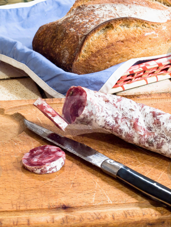 To use this stock image in your creative project, please select the size you need over to the right and click the "Add to Cart" button.
Your downloaded image will come with the Cutcaster watermark removed so don’t worry about the watermark you see on this page. Country french snack stock photo, French dry sausage on a wooden cutting board with slices cut off and a knife. A bread is present in background. by FEL Yannick