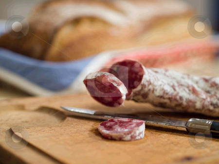 To use this stock image in your creative project, please select the size you need over to the right and click the "Add to Cart" button.
Your downloaded image will come with the Cutcaster watermark removed so don’t worry about the watermark you see on this page. Country french snack stock photo, French dry sausage on a wooden cutting board with slices cut off and a knife. A bread is present in background. by FEL Yannick