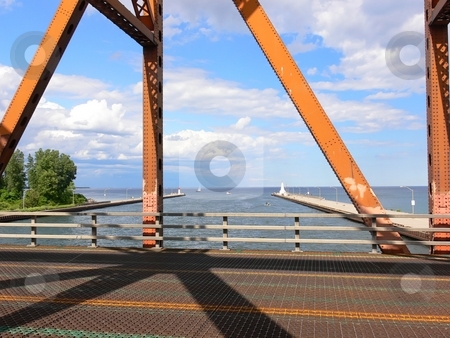 To use this stock image in your creative project, please select the size you need over to the right and click the "Add to Cart" button.
Your downloaded image will come with the Cutcaster watermark removed so don’t worry about the watermark you see on this page. Old lift bridge stock photo, The view trough an loft bridge over the canal to the harbor of Hamilton
on a nice sunny day. by Horst Petzold