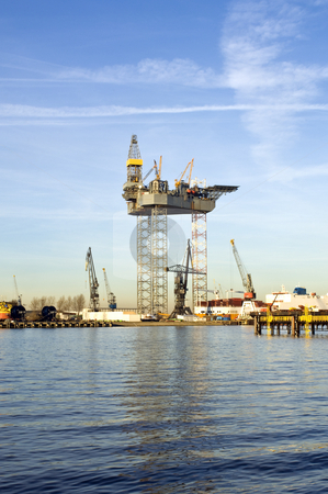 To use this stock image in your creative project, please select the size you need over to the right and click the "Add to Cart" button.
Your downloaded image will come with the Cutcaster watermark removed so don’t worry about the watermark you see on this page. Oil rig construction stock photo, An oil rig is being constructed in a harbor area, to be towed to sea after completion. by Corepics VOF