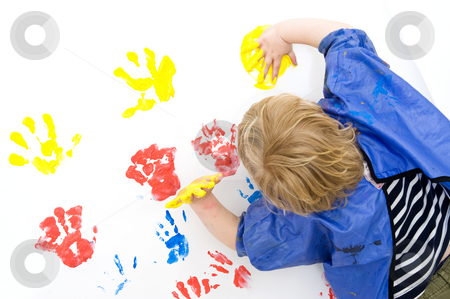 To use this stock image in your creative project, please select the size you need over to the right and click the "Add to Cart" button.
Your downloaded image will come with the Cutcaster watermark removed so don’t worry about the watermark you see on this page. Finger painting stock photo, A boy wearing an apron busy finger painting, with his hands covered in yellow paint by Corepics VOF