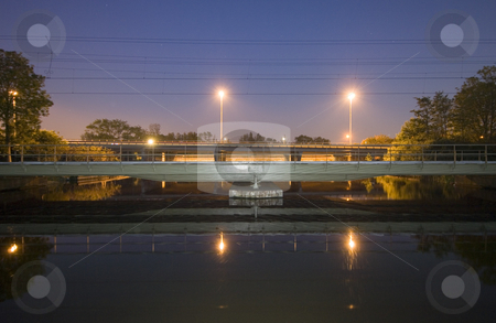 To use this stock image in your creative project, please select the size you need over to the right and click the "Add to Cart" button.
Your downloaded image will come with the Cutcaster watermark removed so don’t worry about the watermark you see on this page. Railway bridge at night stock photo, A railway bridge over a flowing stream at night; with a motorway bridge behind it by Corepics VOF